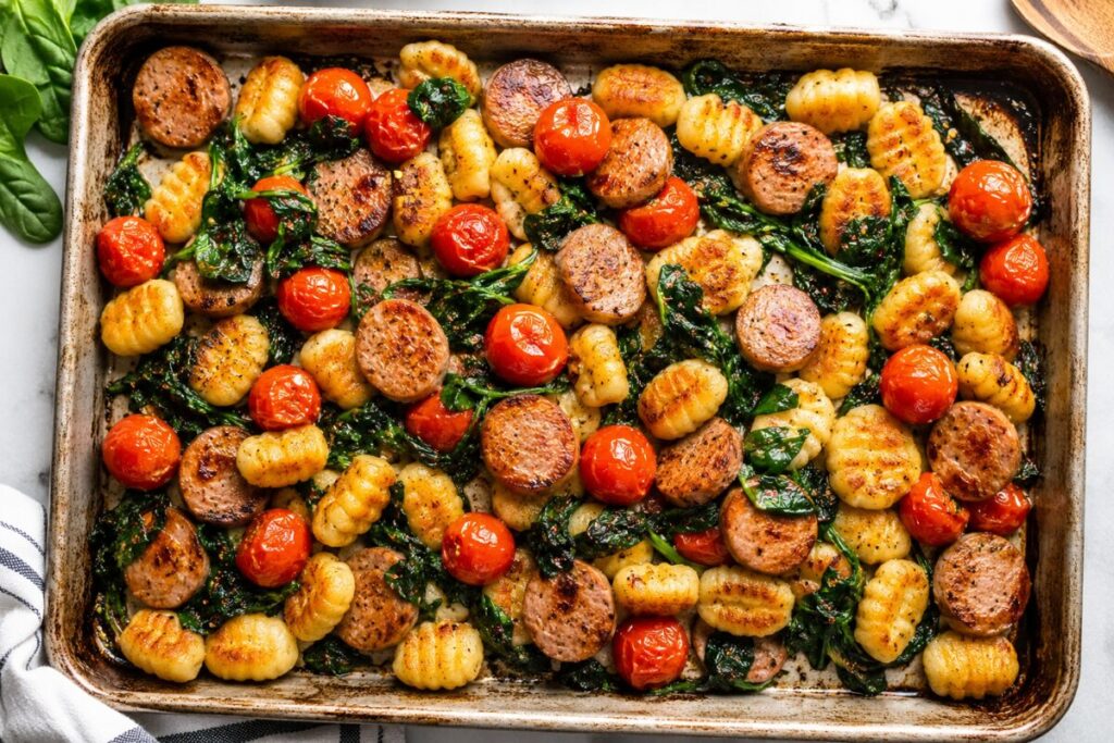 A colorful mix of chicken apple sausage, whole cherry tomatoes, spinach, and roasted gnocchi.
